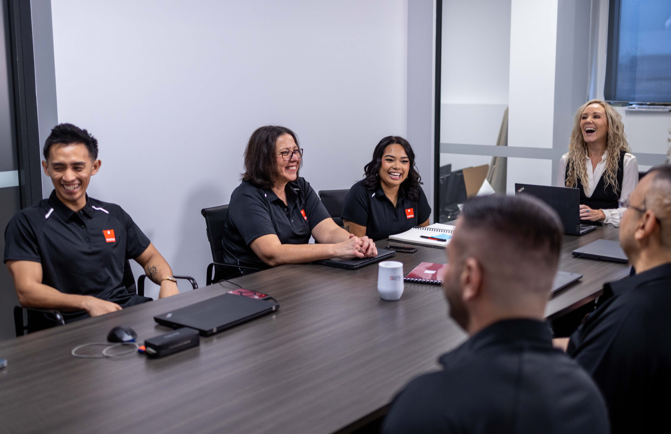 The Synergie Australia team sharing a moment around a meeting table